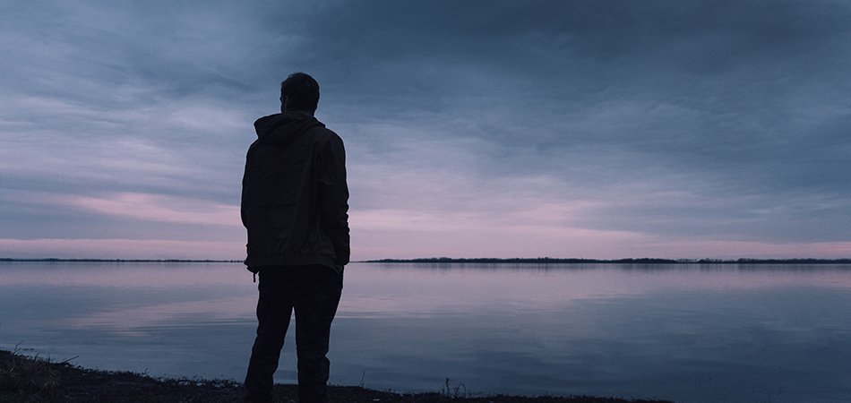 Man standing by a lake | men's mental health