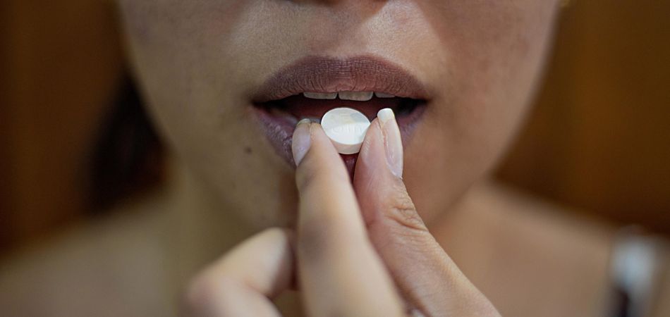 Woman taking herbal medicines tablet | HRI Herbal Medicines